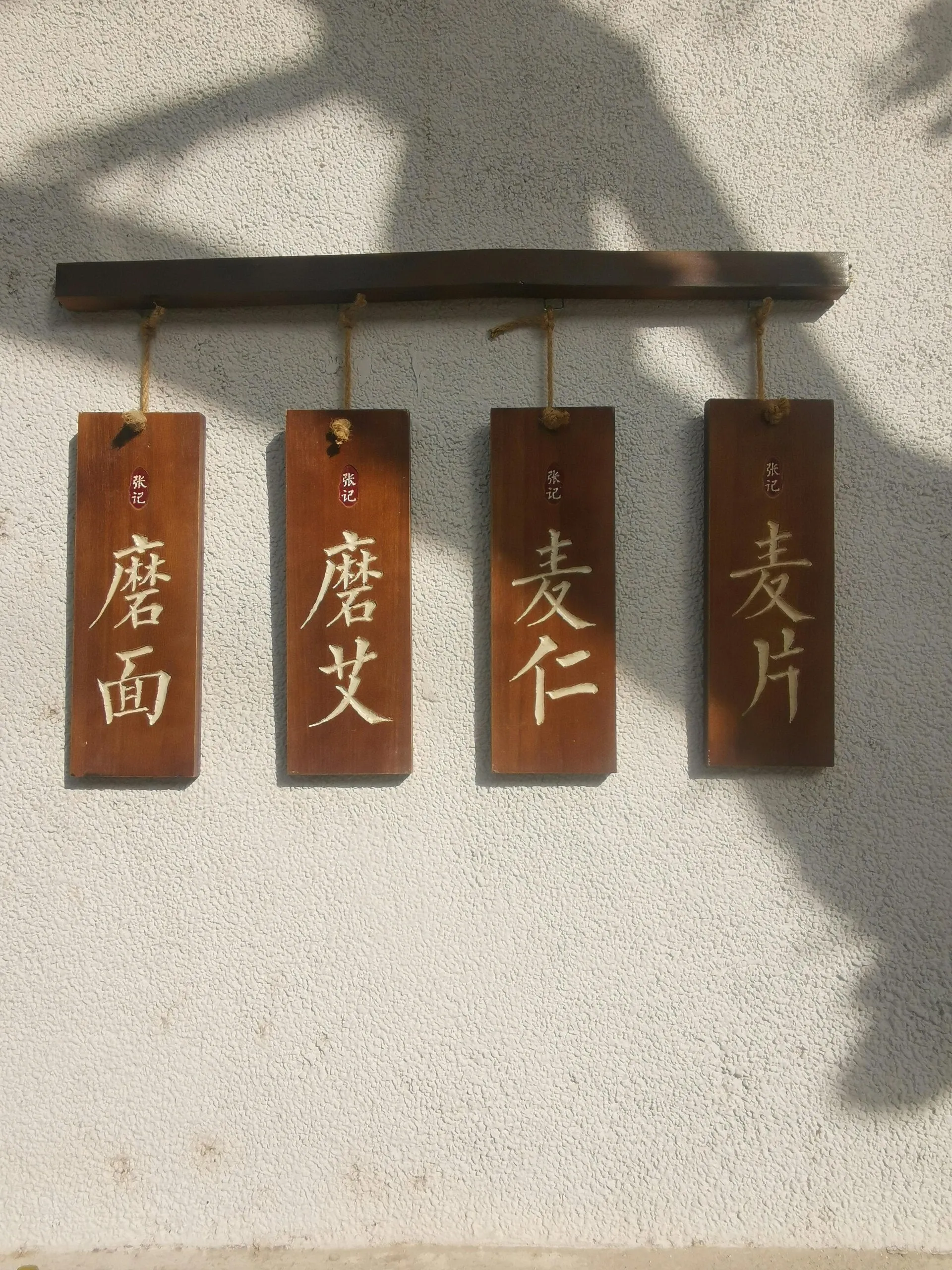 Houten bordjes met Chinese karakters aan een muur